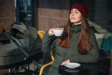 young mother drinks coffee outdoor