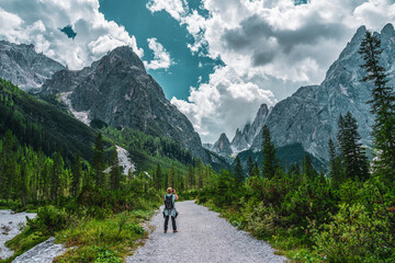 Backpacker on hiking trails in the Dolomites, Italy.