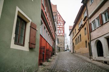 Obraz na płótnie Canvas Medieval narrow street, colorful renaissance and gothic historical buildings, half-timbered houses, paving stone, autumn day, old town, Rothenburg ob der Tauber, Bavaria, Germany