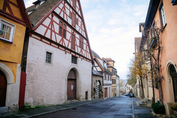 Fototapeta na wymiar Medieval narrow street, colorful renaissance and gothic historical buildings, half-timbered houses, paving stone, autumn day, old town, Rothenburg ob der Tauber, Bavaria, Germany