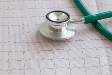 the stethoscope lies on the printout of the cardiogram. Treatment, diagnosis of heart diseases. Close-up, horizontal photo.