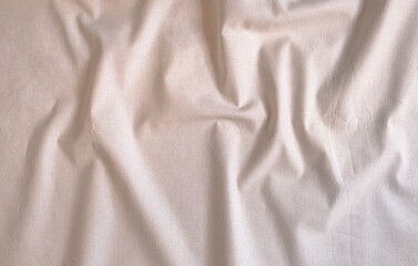 Fototapeta premium Crumpled beige natural fabric with creases and wrinkles background view from above