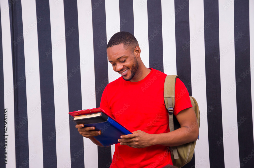 Wall mural young handsome african man studying his book