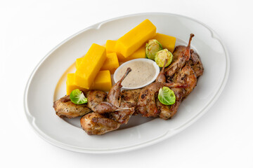 Grilled quails in a sauce with vegetables and herbs. Gentle, diet poultry meat. Banquet festive dishes. Gourmet restaurant menu. White background.