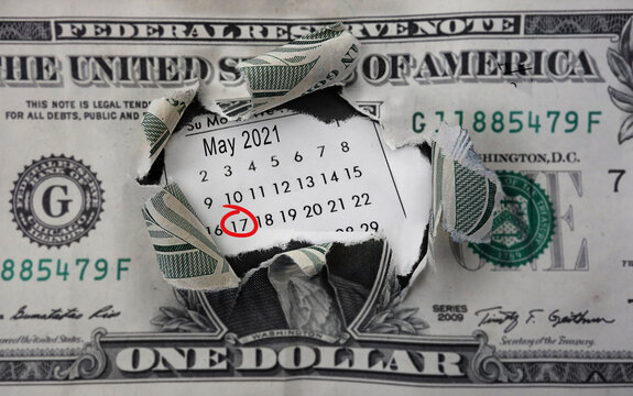 Torn dollar and calendar with May 17th 2021 circled in red, the IRS deadline to pay taxes for 2021