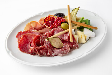 Slicing gourmet meat, prosciutto from beef and pork with berries, cheese, vegetables. Banquet festive dishes. Gourmet restaurant menu. White background.