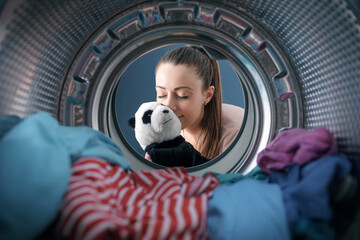 Woman washing a plush in the washing machine