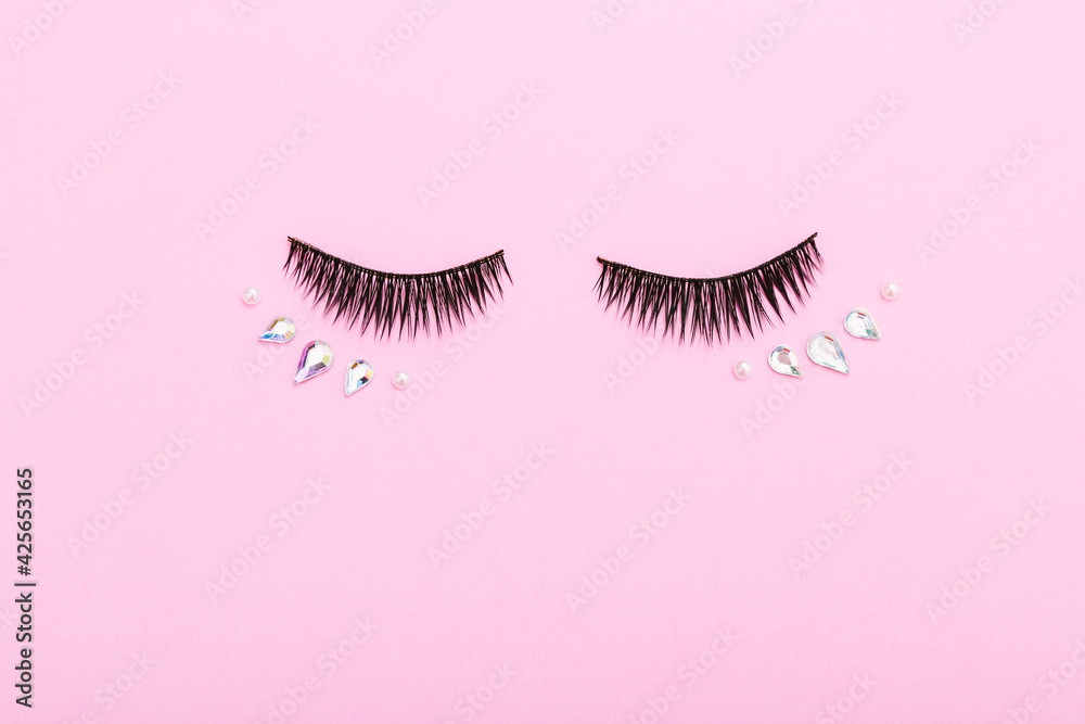 Wall mural False eyelashes and decoration for make up on pink background. Layout of the beauty industry. Beauty and fashion.