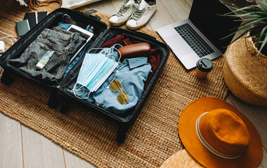 Fototapeta na wymiar Packing suitcase for travel vacation in new normal