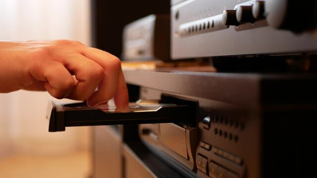 Taking of compact disc from the CD player and putting it in the plastic case, close up