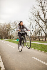 one young woman, riding bicycle Wheelie style.