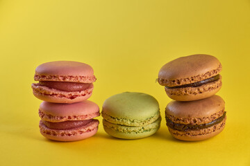 Cake macaron close up on yellow background flavor almond cookies pastel colors.