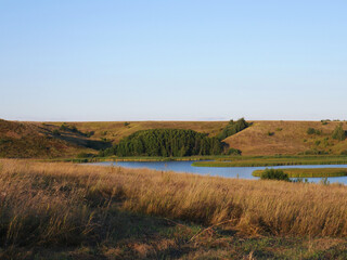 In the distance a pond for growing fish. Summer