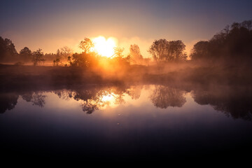 A beautiful river morning with mist and sun light. Springtime scenery of river banks in Northern Europe. Warm, colorful look.