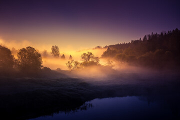 A beautiful river morning with mist and sun light. Springtime scenery of river banks in Northern Europe. Warm, colorful look.