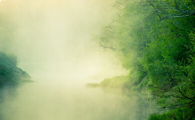 A beautiful river morning with mist and sun light. Springtime scenery of river banks in Northern Europe. Warm, colorful look.