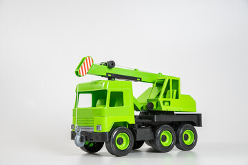 Plastic car. Toy model isolated on a white background. Green truck mounted crane.