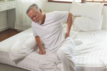 Obraz na płótnie Canvas Asian Elderly back pain and sit in bedroom.
