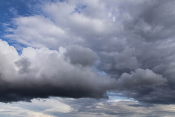 Storm sky. Dark grey big cumulus clouds against blue sky background, cloud texture, thunderstorm	
