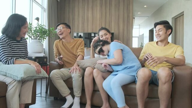 happiness weekend vacation asian family grandparent parent and daughter sitting together on sofa couch in living room home sweet home ideas concept