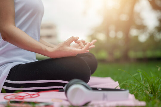 Close up of a woman hand doing yoga meditation and lotus pose at the park.