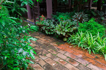 A walkway in the garden, which is paved with red bricks as a walkway