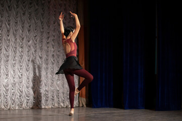 Ballerina spin. A girl in a black skirt is dancing on stage. Speech by a teenager in a dance class. Beautiful body movements.