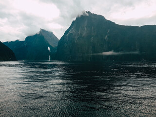 series of waterfalls with a visual on a boat in milford sounds