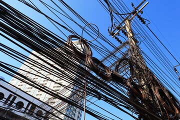 The wires and cables on the messy electric poles are common in Bangkok.
