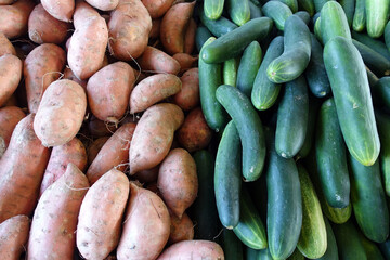 Piles of Yams and Cucumbers for Sale at a Farmers Market