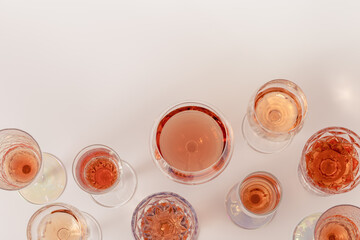 Rose wine assortment in crystal glasses, rose champagne sparkling wine on light background. Summer alcoholic drink