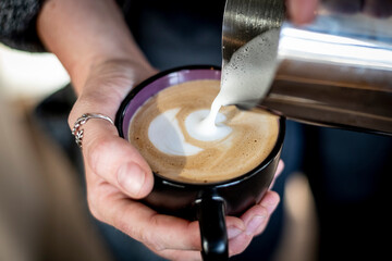 Barista making a cup of coffee latte art.