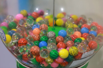 Small colored balls in a coin vending machine in the mall.