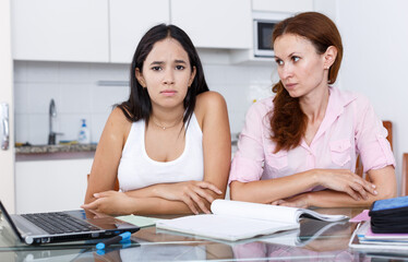 Mother upset because her daughter is not studying well, scene in kitchen