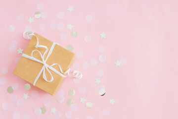 Fototapeta premium Paper gift box tied with ribbon, star and circle paper confetti or glitters