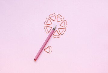 Creative flower composition with heart shaped clips and a pen