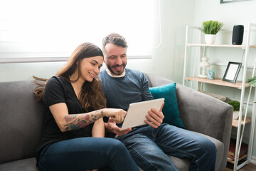 Attractive couple using a tablet in the living room