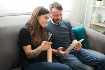 Obraz premium Hispanic couple doing online shopping with a credit card