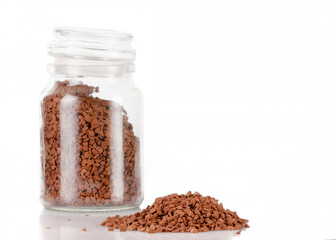 Fragrant coffee is poured into a glass jar. There is a pile of spilled coffee nearby.