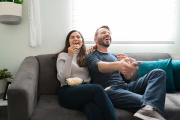 Cheerful couple watching a movie during a leisure day