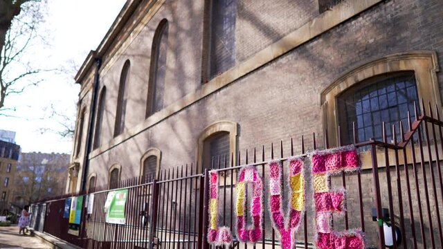 Message of love, street art outside a church in London on a sunny day, written in big pink letters