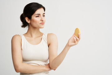 Pretty woman in a white T-shirt Sponge in hands cleaning face