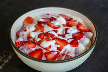 Red strawberry and white yogurt brulee. Fruit dessert on breakfast with wedges of perfectly ripe in season strawberry