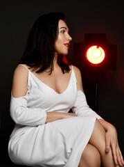 Mature good looking brunette woman actress during interview. Lady oin white fress with deep...