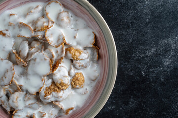 Fototapeta na wymiar Whole grain glazed flakes with yogurt in plate. Healthy breakfast, whole grain muesli in a bowl