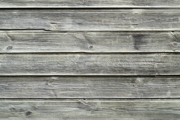 Rustic background. Wooden wall of an old house. Horizontal gray boards close up. Place for text, copy space.