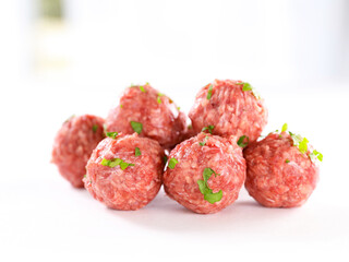 raw meatball and herb on white