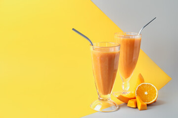 Glasses of healthy smoothie and ingredients on color background
