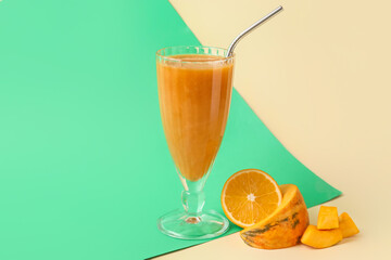 Glass of healthy smoothie and ingredients on color background