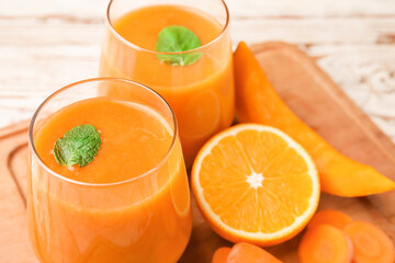 Glasses of healthy smoothie and ingredients on wooden background